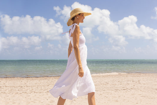 Woman wearing White Sleeveless Ruffle Dress on beige background