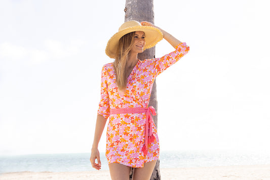Woman standing in front of palm tree wearing Surfside Wrap Romper