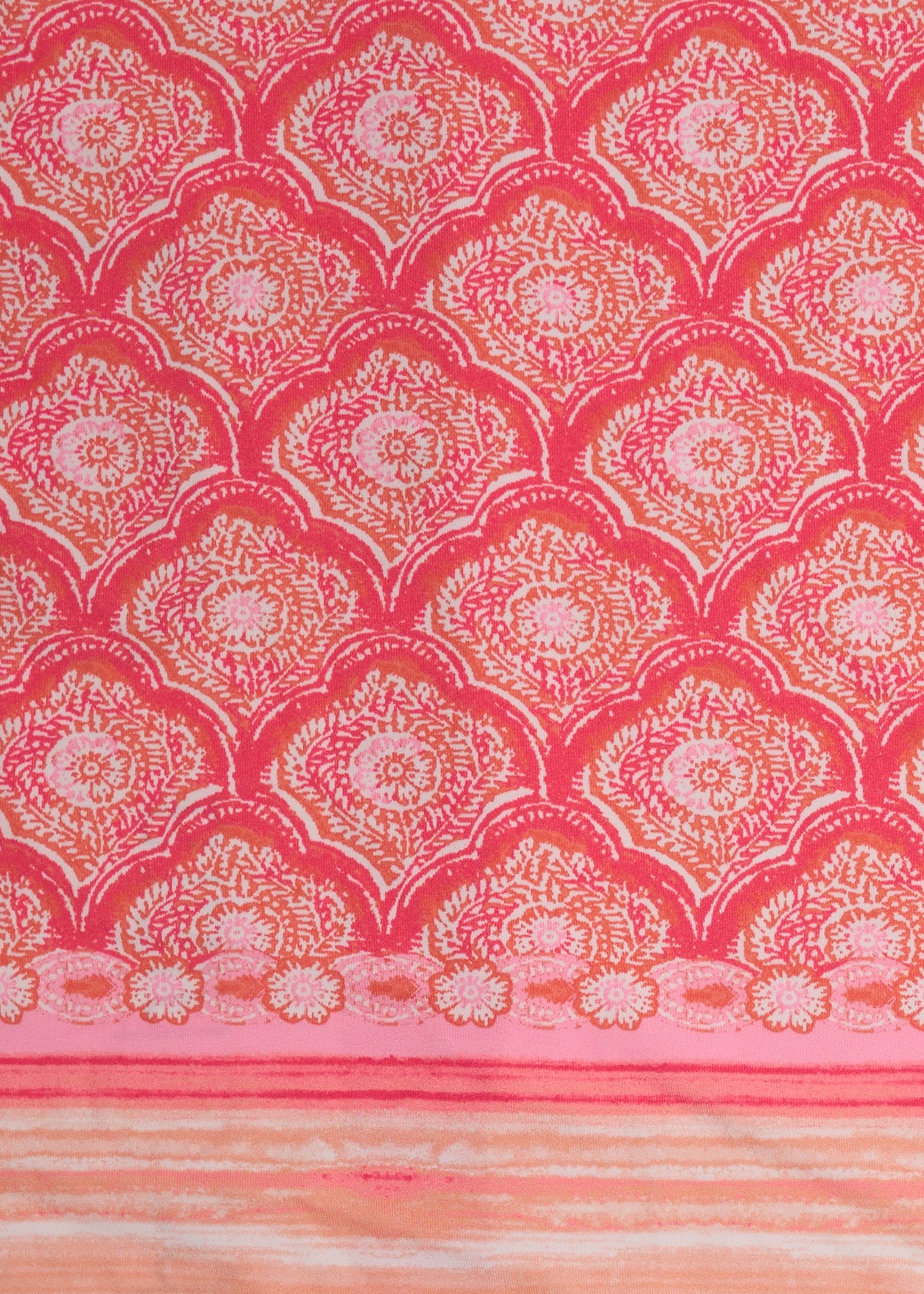 A close up of Cabana Life's Amelia Island pink and coral colored tile print with a watercolor stripe border on a UPF 50+ woven fabric.
