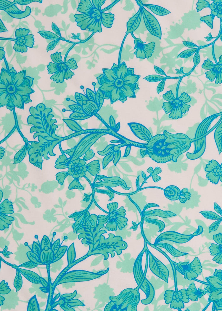 A close up of the UPF 50+ green and blue floral fabric on the Cabana Life Rosebay Ruffle Short Sleeve Dress.