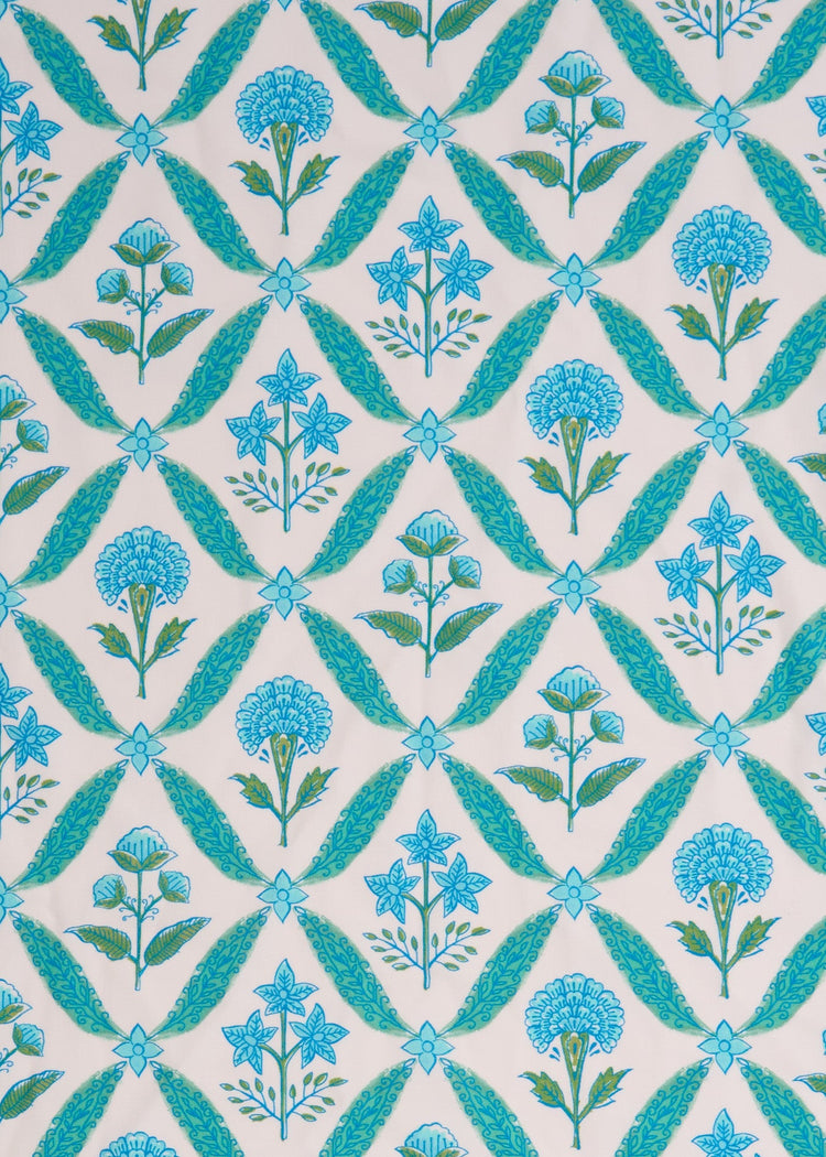 A close up of the sun protective green and blue floral tile pattern on the woven Cabana Life Rosebay Smocked Maxi Dress.