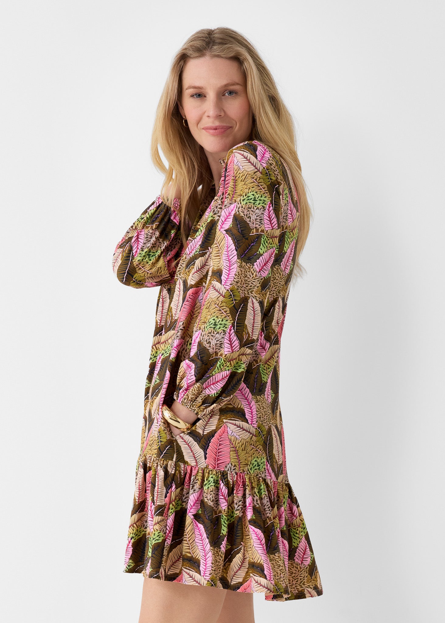 Woman wearing our Myers Relaxed Dress on a plain background turned to the side. 