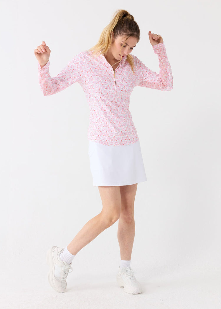 A woman wearing the sun protective Cabana Life 17" Skort while twirling so you can see the light fabric spin. 