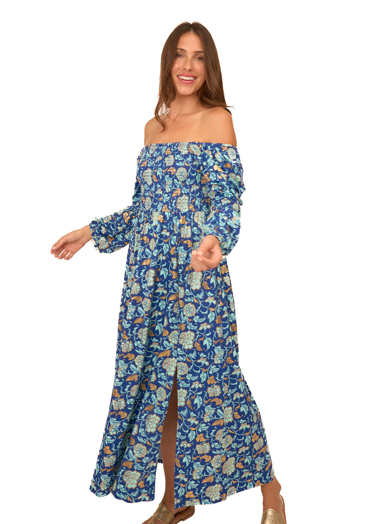 A brunette woman wearing Cabana Life's sun protective Navy Floral Metallic Puff Sleeve Maxi Dress as an off the shoulder style on a white background.