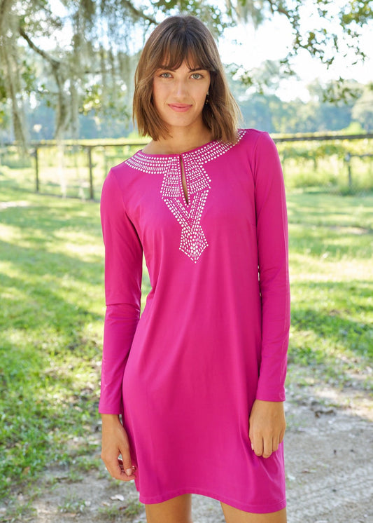 Brunette woman with short hair and bangs wearing Merlot Metallic Key Hole Dress.on a dirt road in front of a grassy field.