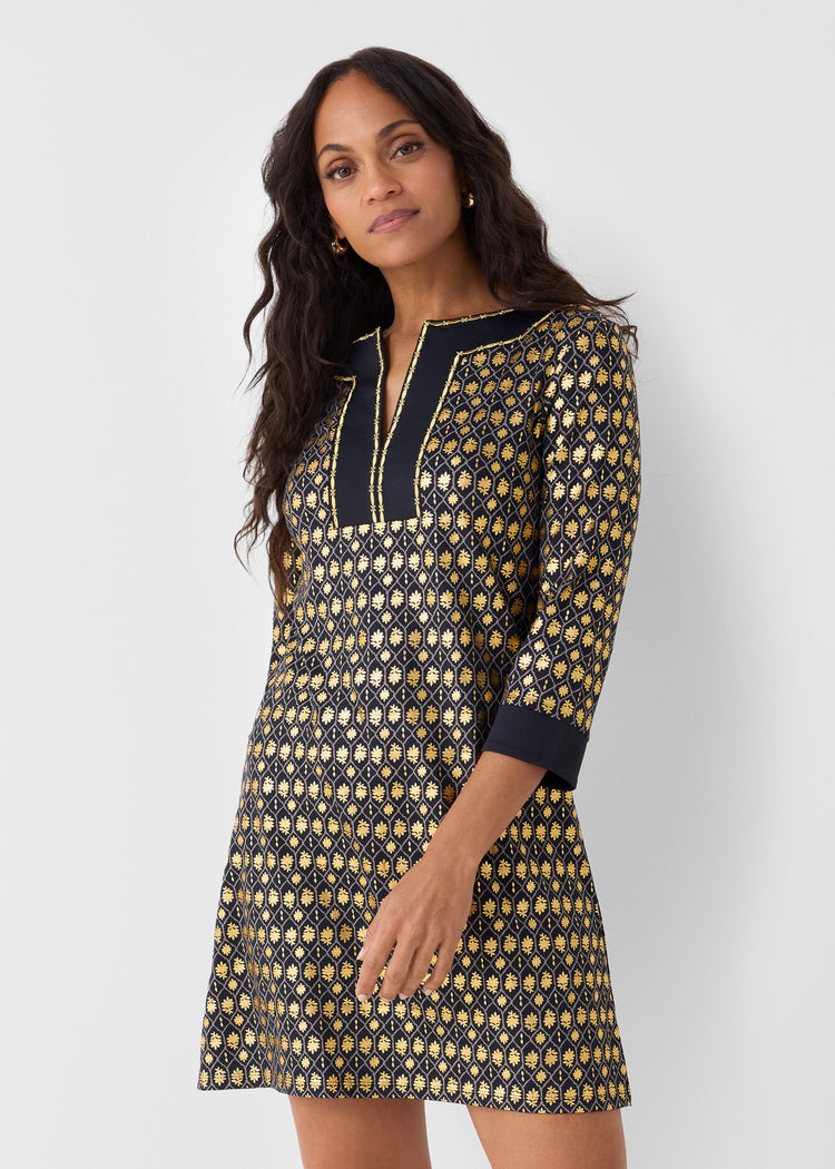 Woman wearing a patterned dress with a plain background