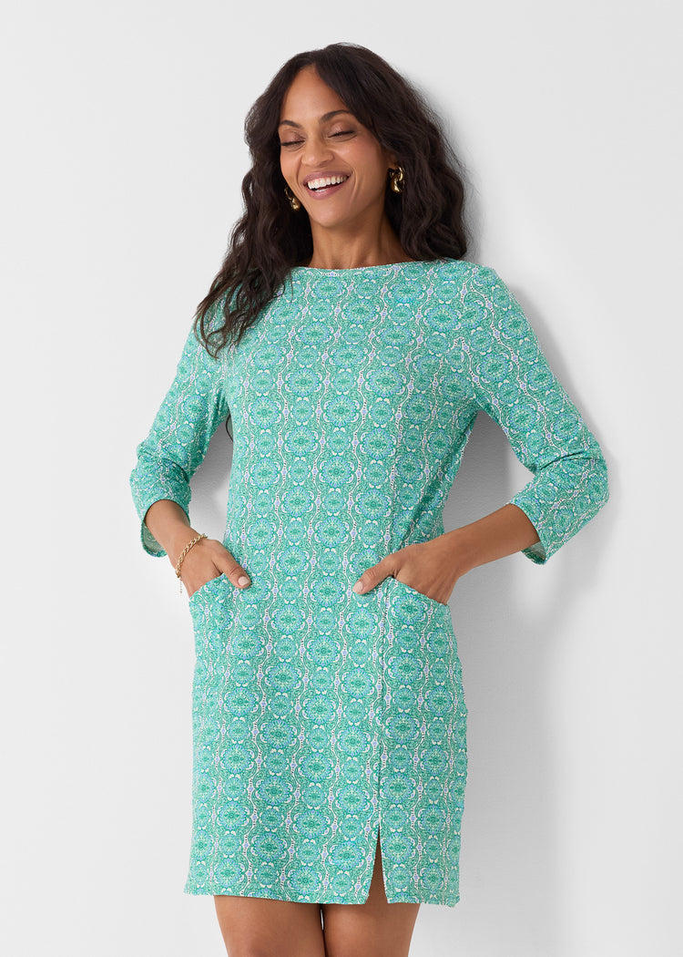 Woman wearing a green patterned dress against a white background