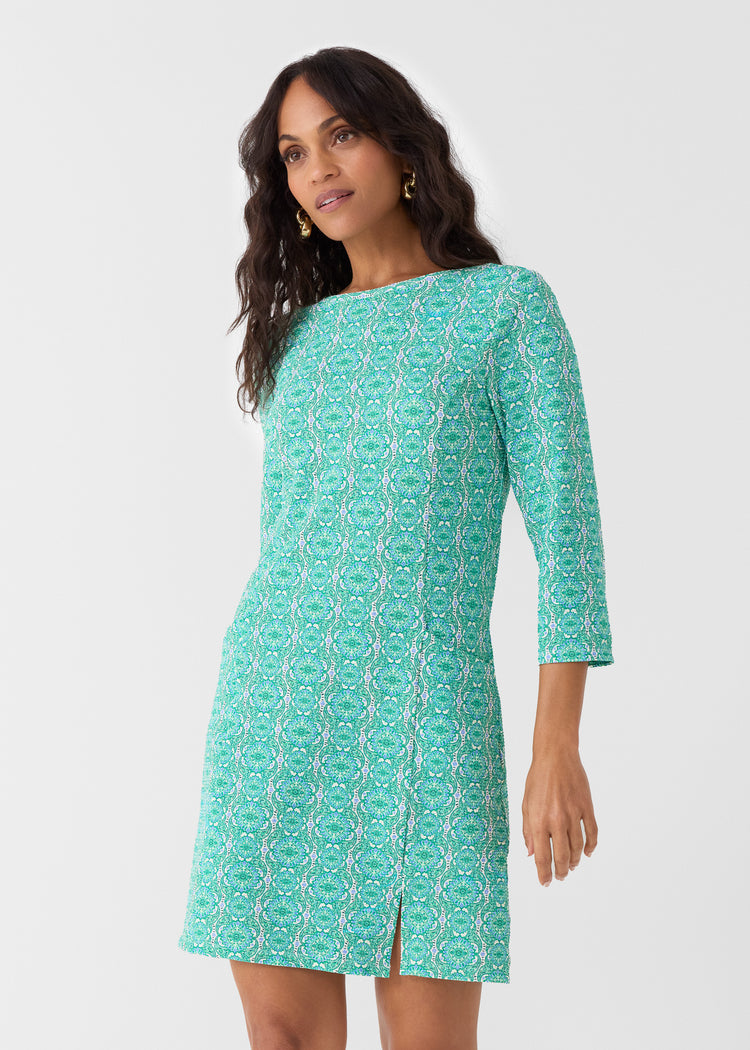 Woman wearing a green patterned dress on a white background