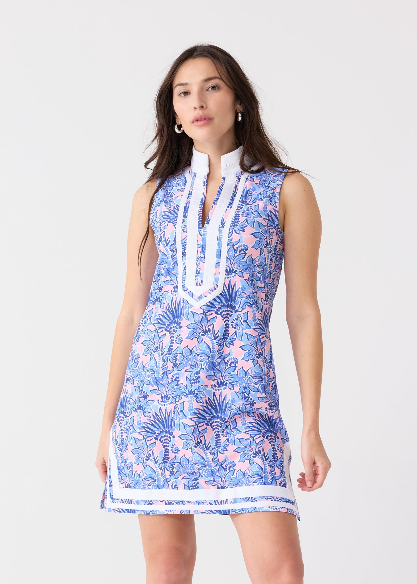 A brunette woman wearing the Cabana Life sun protective Palm Beach Sleeveless Tunic Dress at a studio.