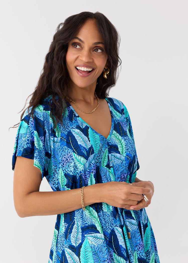 Woman wearing a blue and green patterned dress on a white background