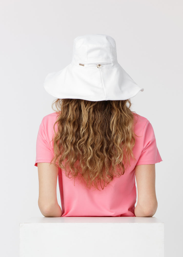 Brunette woman wearing our UPF 50+ White Reversible Wide Brim Sun Hat showing the back of the hat.