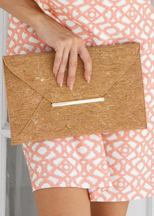Person holding a cork clutch with a patterned dress