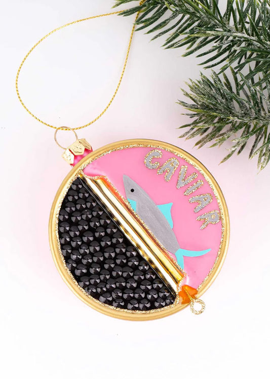 Decorative ornament with a fish design and 'Caviar' text, hanging from a branch.