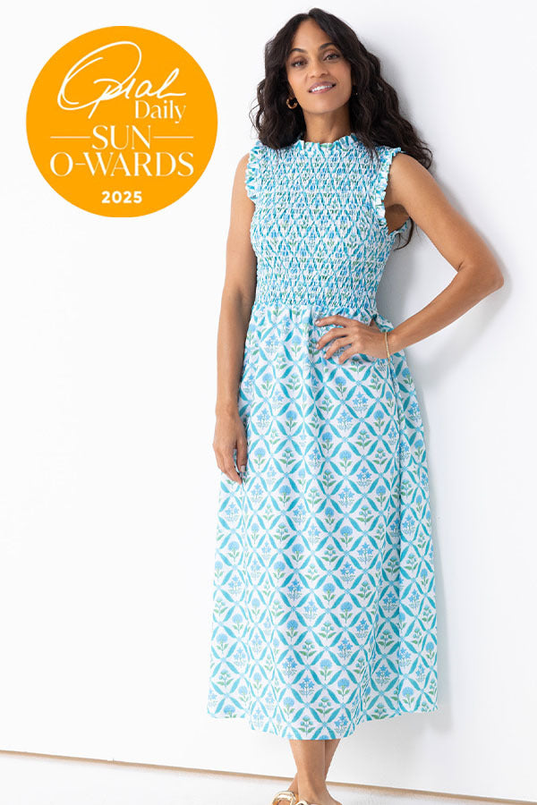 Woman wearing a blue patterned dress with 'Oprah Daily Sun O'Wards 2025' badge on a white background