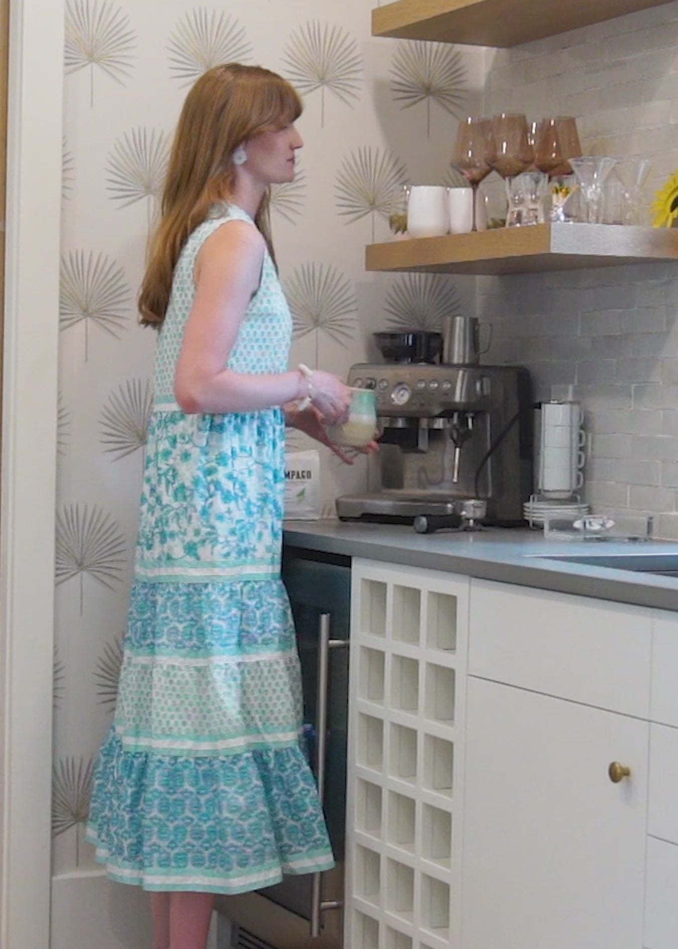 A redhead woman wearing the Cabana Life sun protective Rosebay Sleeveless Tiered Maxi Dress inside a house.