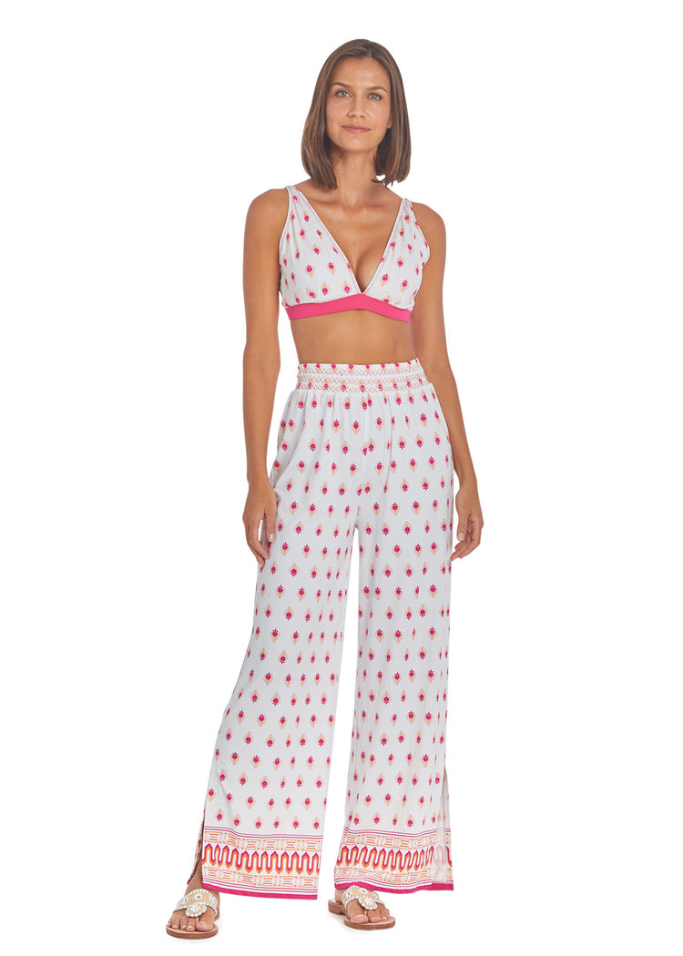 Woman wearing Tulum Reversible Triangle Bikini Top white side and Tulum Palazzo Pants