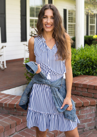 Woman wearing Sleeveless Ruffle Dress with denim jacket tied around waist