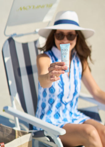 Woman wearing Cabana Life holding TiZO sunscreen