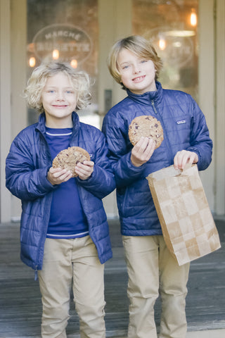 Two boys holding large cookies wearing Boy's Navy Rashguards