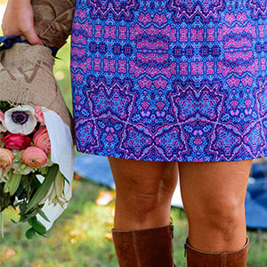 Ryanne holding a bouquet of flowers while wearing the Carolina purple and pink dress