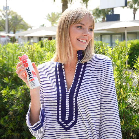Woman wearing Navy Stripe Terry Tunic holding sunscreen