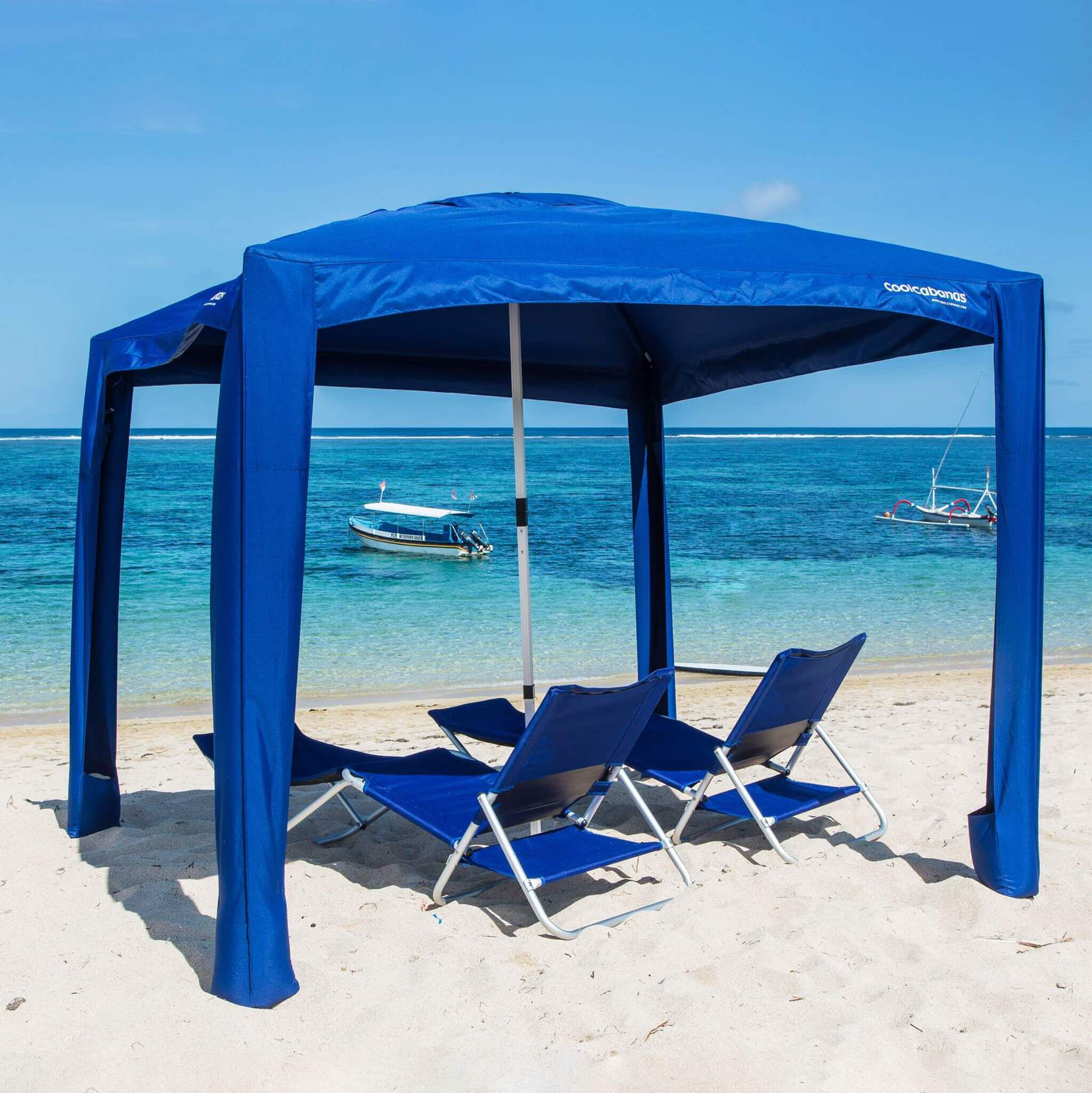 CoolCabanas | Cool Cabana 5 Solid Navy set up on beach with Set of 2 CoolCabana Beach Loungers underneath 