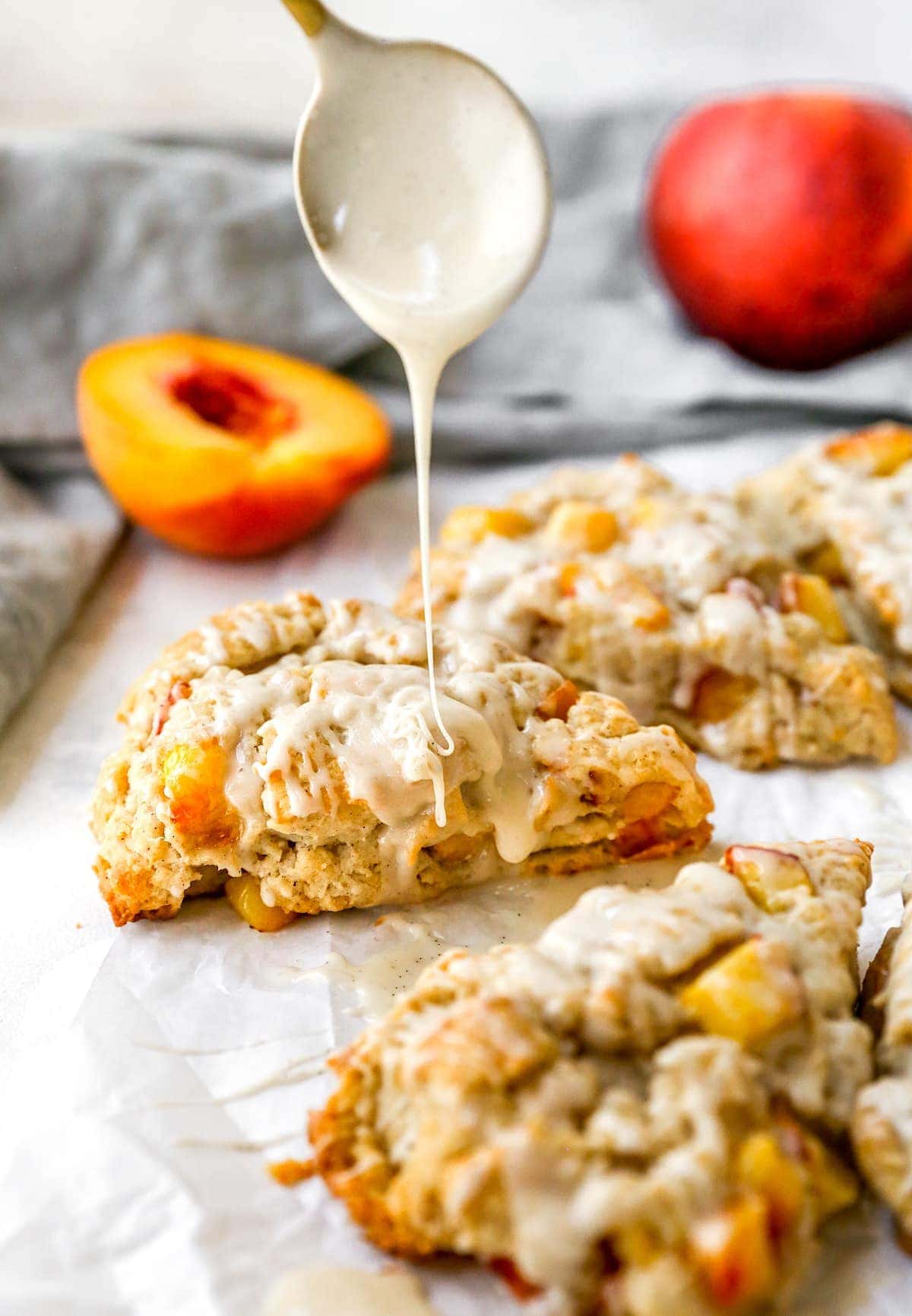 peach scones being drizzled with glaze